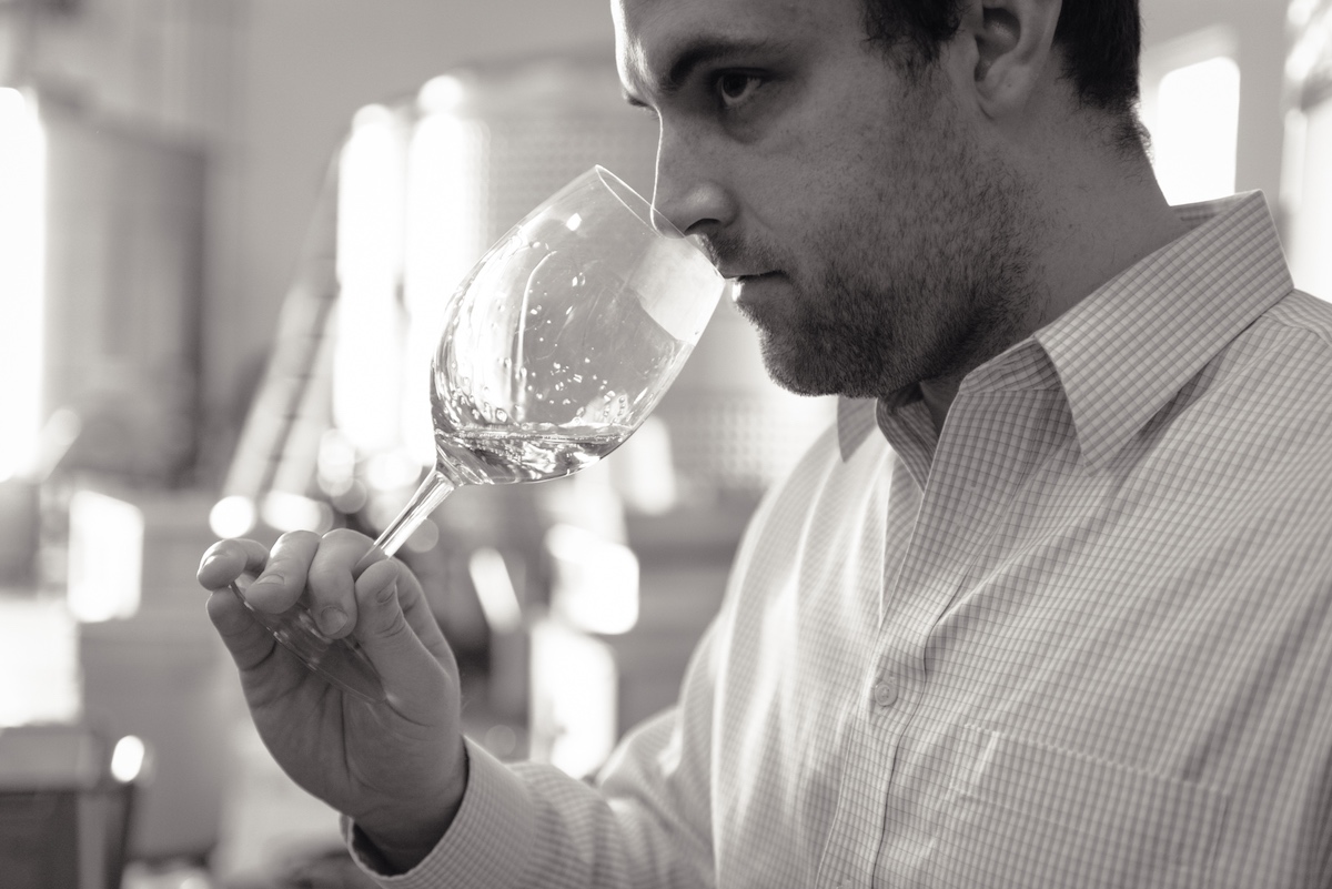 Cameron Metzker smelling the aromatics from a glass of the Metzker Family’s Ritchie Vineyard Chardonnay.