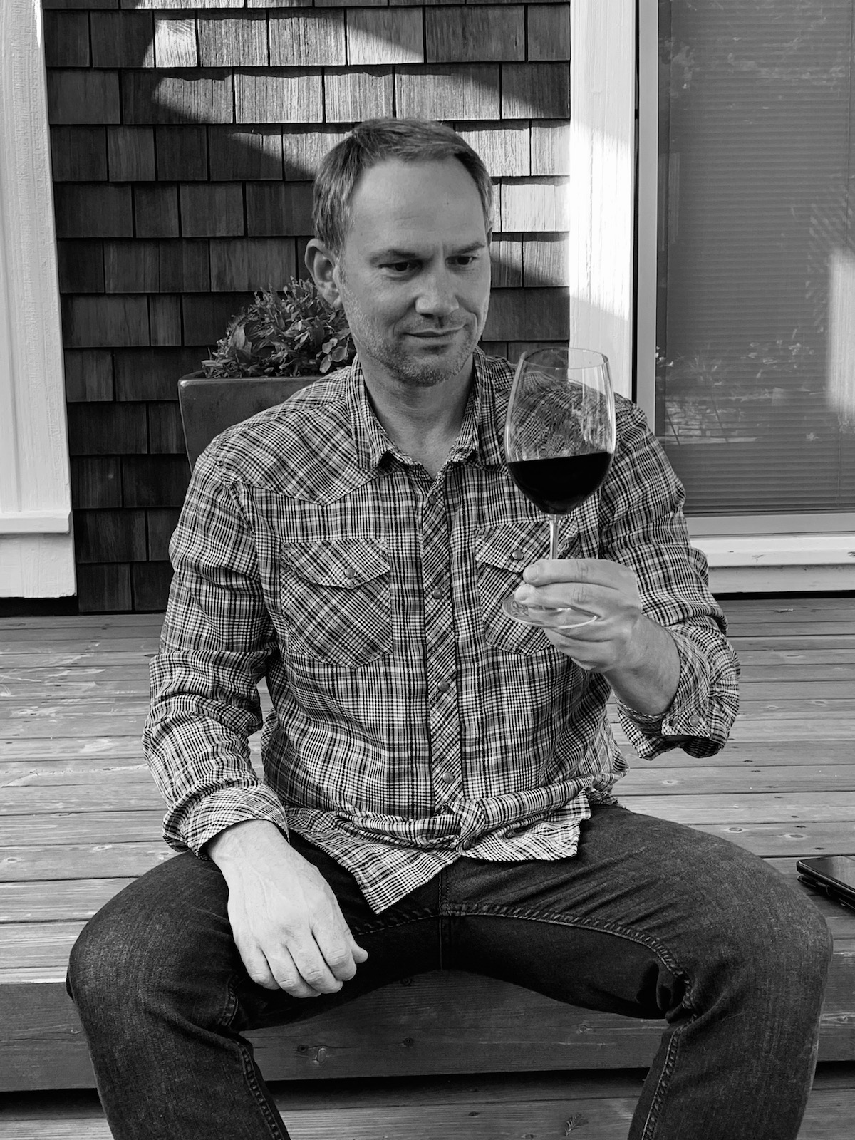 John Martin sitting on a deck while tasting the Metzker Family Estate Cabernet Sauvignon.